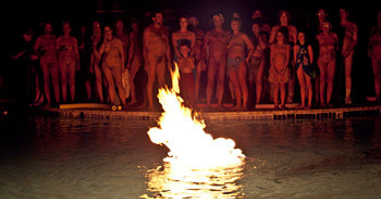 group of nudists enjoying evening camp fire at Sun Medow Nudist Resort
